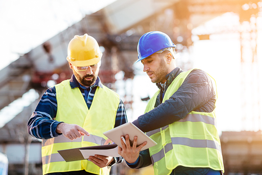 Bauarbeiter mit Tablet auf der Baustelle